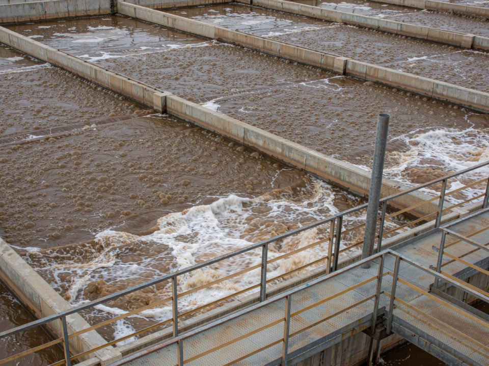 Aeration basin of a wastewater treatment plant with churning water and surface foam