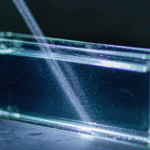 Light beam scattering through a water sample in a glass cuvette