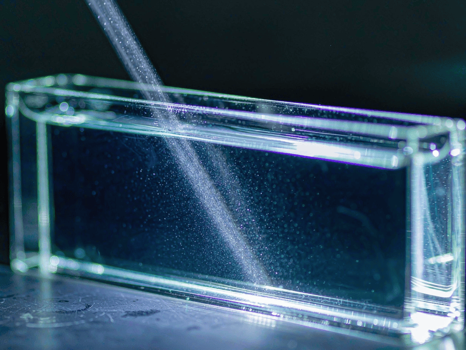 Light beam scattering through a water sample in a glass cuvette